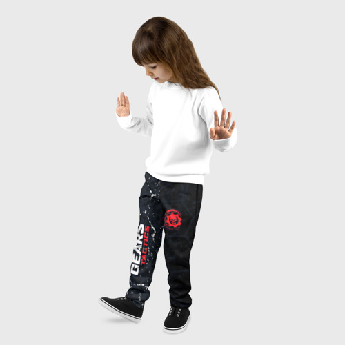 Детские брюки 3D с принтом Gears of War красно-белой лого на темном фоне, фото на моделе #1