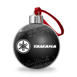 Ёлочный шар Yamaha Speed на темном фоне со следами шин: надпись и символ